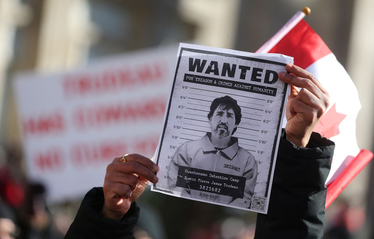 A protester holds up a wanted poster of Prime Minister Justin Trudeau as protesters gather around Queen's Park in Toronto on February 5.