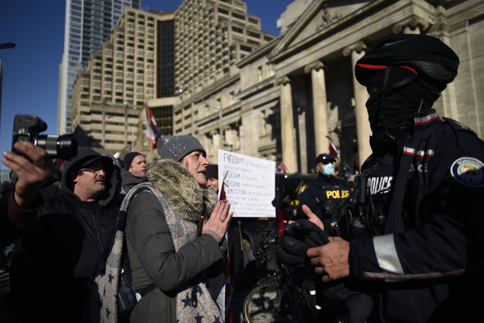 A protester requests that police let trucks come close to Queen's Park during a protest at the park to support the truckers and denounce the government's vaccination policy.