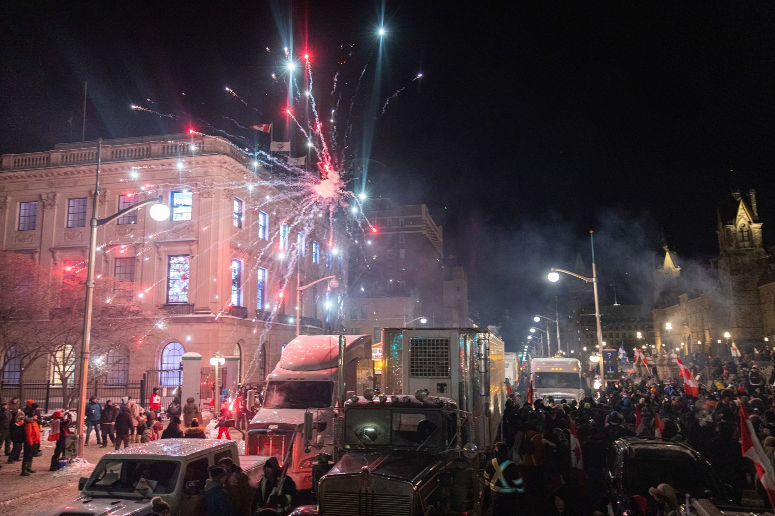 Protesters party as a firework explodes in front of Parliament Hill during a rally in Ottawa on January 29.