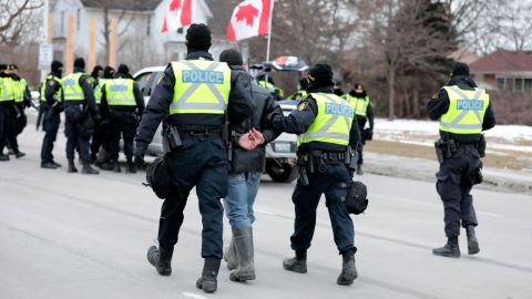 Police detain a man Sunday after protesters denouncing Covid-19 vaccine mandates blocked the entrance to the Ambassador Bridge in Windsor, Ontario.