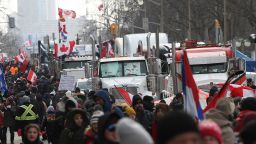 Protesters and supporters walk pass parked trucks as demonstrators continue to protest the Covid-19 mandates on February 12, 2022 in Ottawa, Canada. (Photo by Dave Chan / AFP) (Photo by DAVE CHAN/AFP via Getty Images)