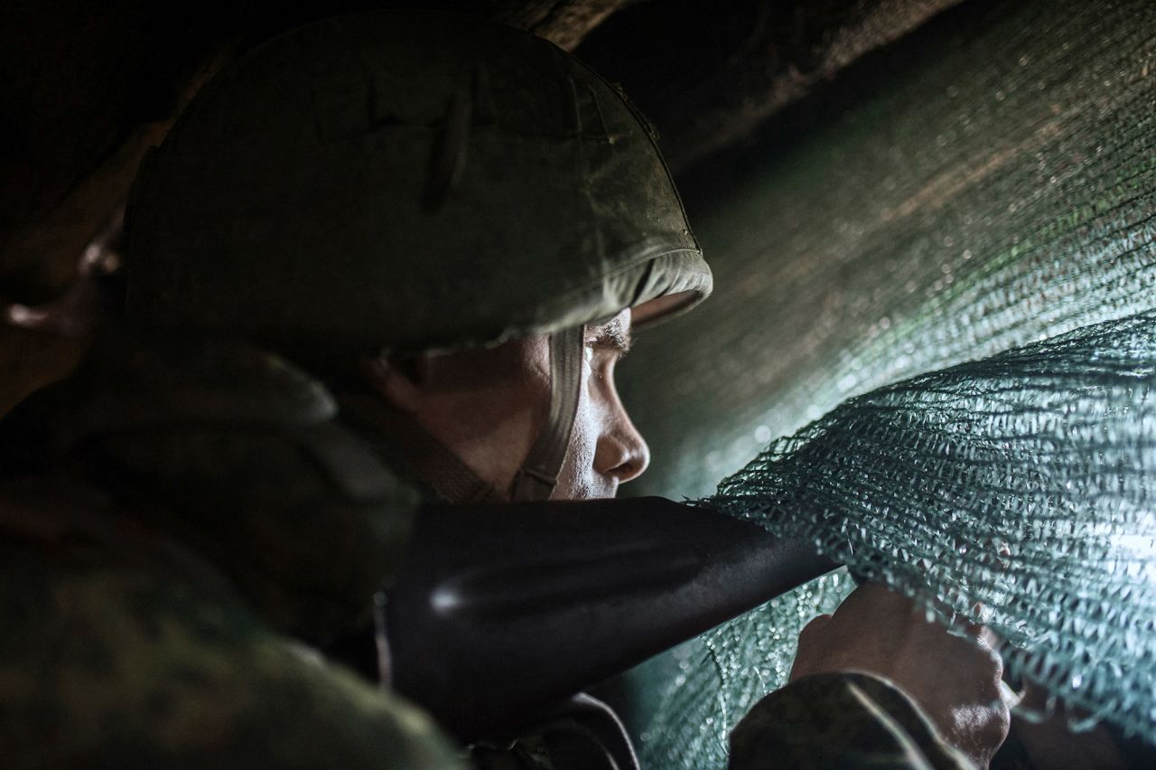 Pro-Russian separatists observe the movement of Ukrainian troops from trenches in Ukraine's Donbas area on February 11.