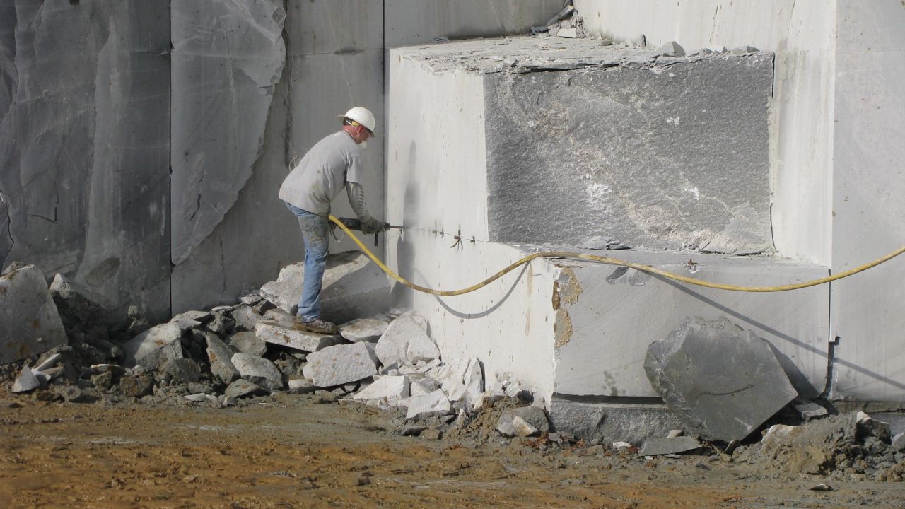 A quarry worker drills holes in a block of granite in Elberton, Georgia, preparing it to be removed. 
