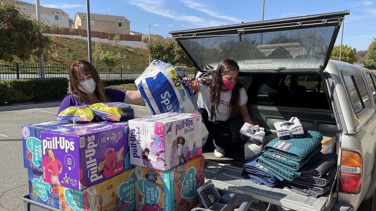 Two-time Olympian Anita Alvarez (R) unloading donations with the Purple Project.