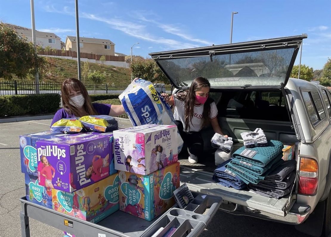 Two-time Olympian Anita Alvarez (R) unloading donations with the Purple Project.