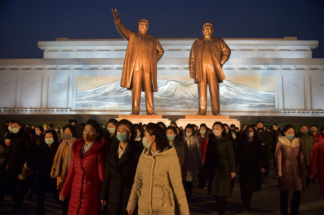 People gather before the statues of late North Korean leaders Kim Il Sung and Kim Jong Il in 2021 to mark the 10th anniversary of Kim Jong Il's death.