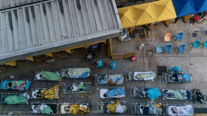 HONG KONG, CHINA - FEBRUARY 15: Patients displaying Covid-19 symptoms lay in beds as they wait at a temporary holding area outside Caritas Medical Centre on February 15, 2022 in Hong Kong, China. Health authorities confirm a new daily record of 1,600 infections while near a record high of 5,400 people tested preliminary positive. At least 10,000 infected people are waiting to be admitted to Hong Kong hospitals as cases overwhelm the public health care system.(Photo by Anthony Kwan/Getty Images)