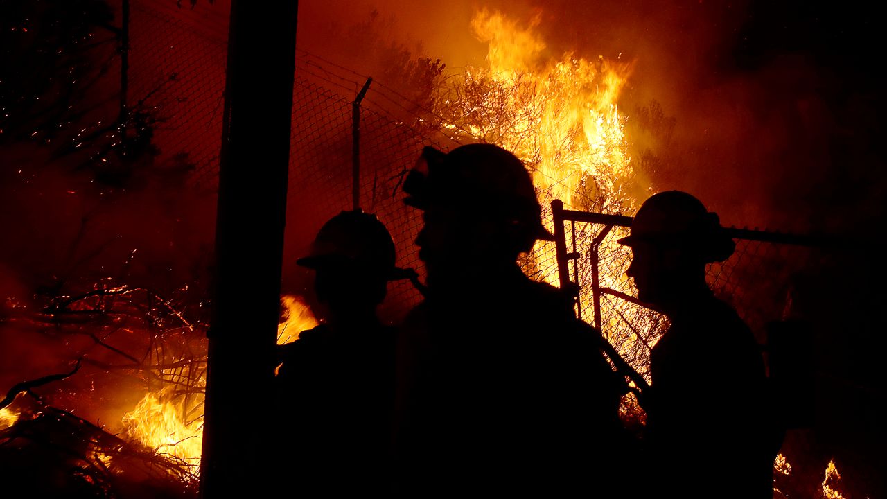 California firefighters battle wildfires day and night as homes are threatened nearby.