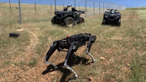 A handout photo from the Department of Homeland Security shows a robot dog built by Ghost Robotics operating alongside ATVs in the southwestern United States. 