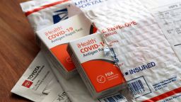 Free iHealth COVID-19 antigen rapid tests from the federal government sit on a U.S. Postal Service envelope after being delivered.