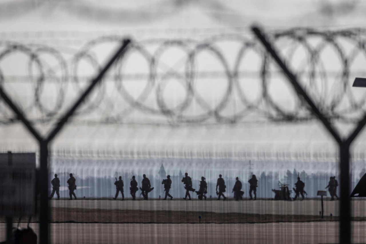 US troops walk on the tarmac at the Rzeszów-Jasionka Airport in southeastern Poland on February 16. US paratroopers landed in Poland as part of a deployment of several thousand sent to bolster NATO's eastern flank in response to tensions with Russia.