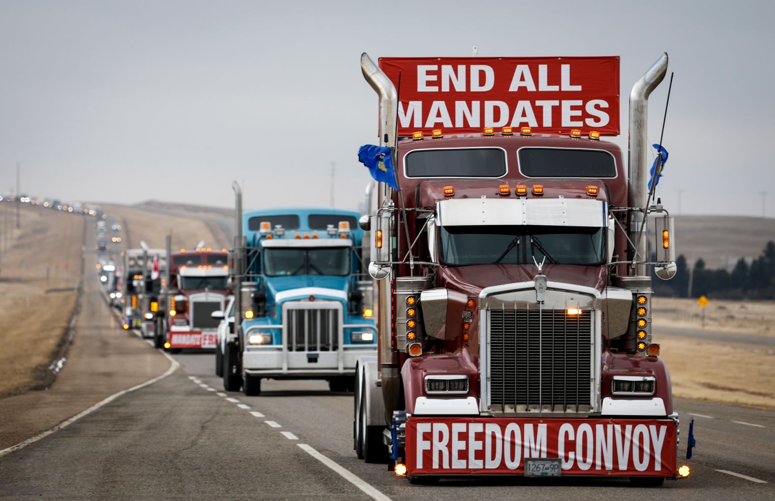 A truck convoy departs Coutts, Alberta, after blocking the highway at the US border crossing on Tuesday, February 15.