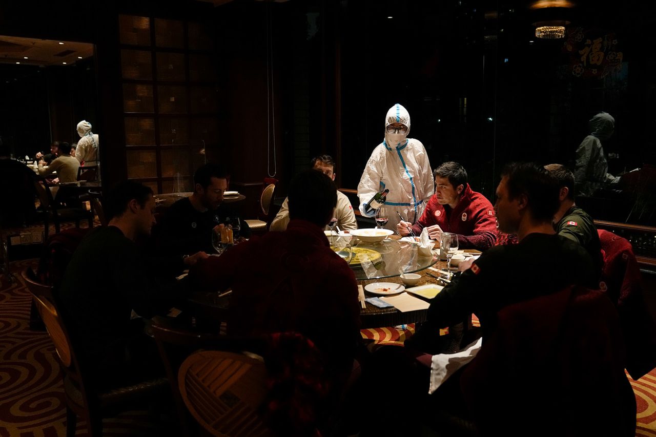 A waitress wearing protective gear serves a table at a hotel restaurant inside the <a href="https://www.cnn.com/2022/01/21/china/beijing-winter-olympics-covid-quarantine-explained-mic-intl-hnk/index.html" target="_blank">Olympic bubble</a> on February 16. The Beijing Olympic Committee <a href="https://www.cnn.com/world/live-news/beijing-winter-olympics-02-17-22-spt/h_bc4149580ecbcfd278b4739c74f899a7" target="_blank">identified no new Covid-19 cases</a> among Games-related personnel on Wednesday, it said in a statement. It was the first time no new infections had been detected since the beginning of the Winter Olympics, and it followed a steady decline in cases for the past two weeks.