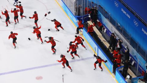 Canada's players rush onto the ice in celebration after beating Team USA in the women's ice hockey gold medal match.
