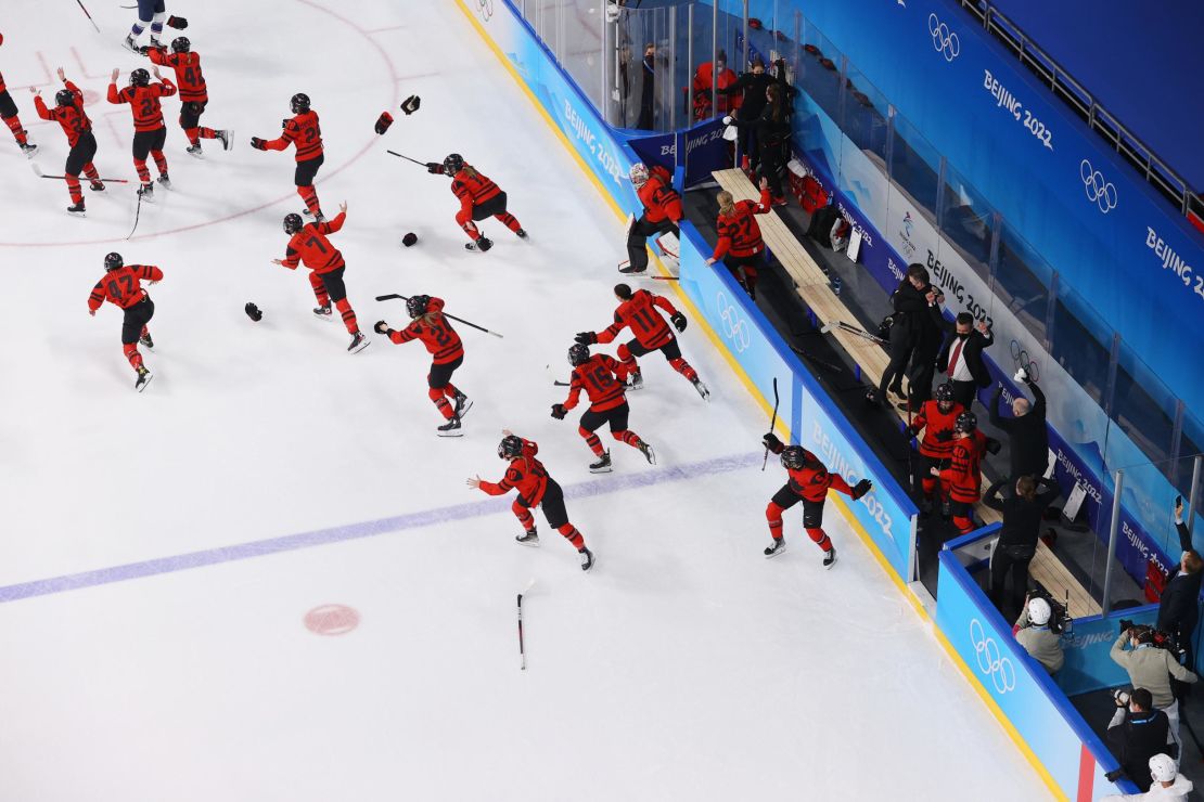 Canada's players rush onto the ice in celebration after beating Team USA in the women's ice hockey gold medal match.