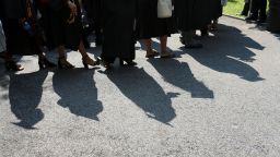 College graduates walk to their seats at their commencement ceremony in Manhattan on May 31, 2019. 