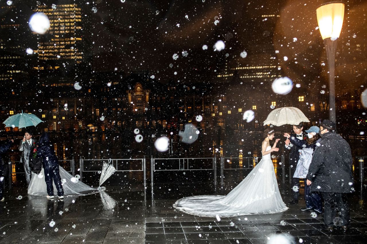 Couples prepare for wedding photos in front of Tokyo Station as it snows in the Japanese capital on Thursday, February 10.