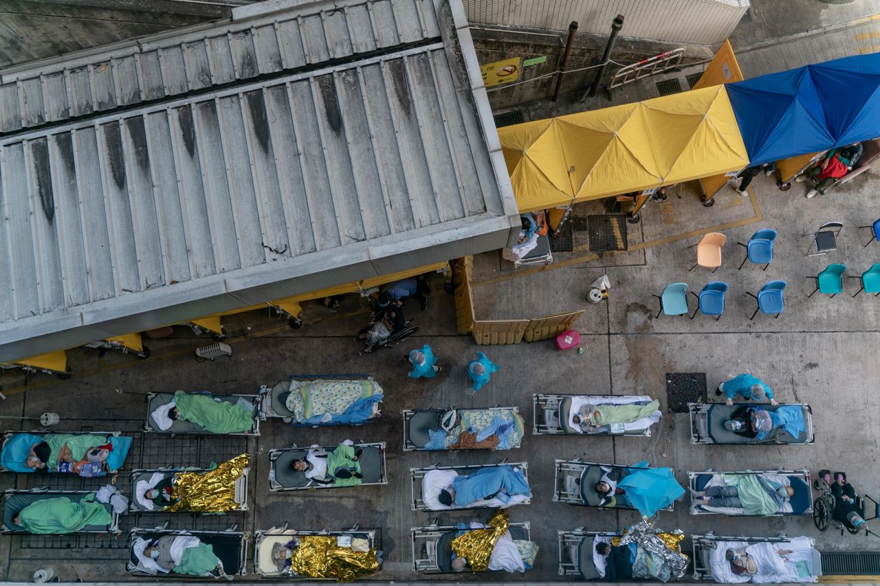 Patients displaying Covid-19 symptoms lie in beds at a temporary holding area outside the Caritas Medical Centre in Hong Kong on Tuesday, February 15. Hospitals in Hong Kong have been overwhelmed by <a href="https://www.cnn.com/2022/02/16/china/hong-kong-covid-singapore-mic-intl-hnk/index.html" target="_blank">the city's biggest outbreak yet of Covid-19.</a>