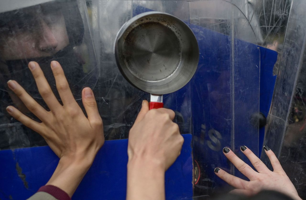 A protester holds a pan against a police officer's riot shield in Istanbul on Sunday, February 13. A feminist group was protesting higher energy prices and the rising cost of living in Turkey.