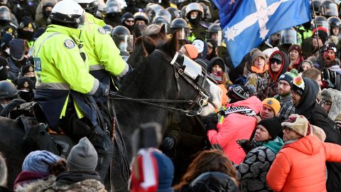 Officers on horseback try disperse protesters in Ottawa on Friday.
