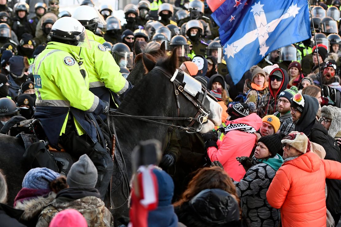 Officers on horseback try disperse protesters in Ottawa on Friday.