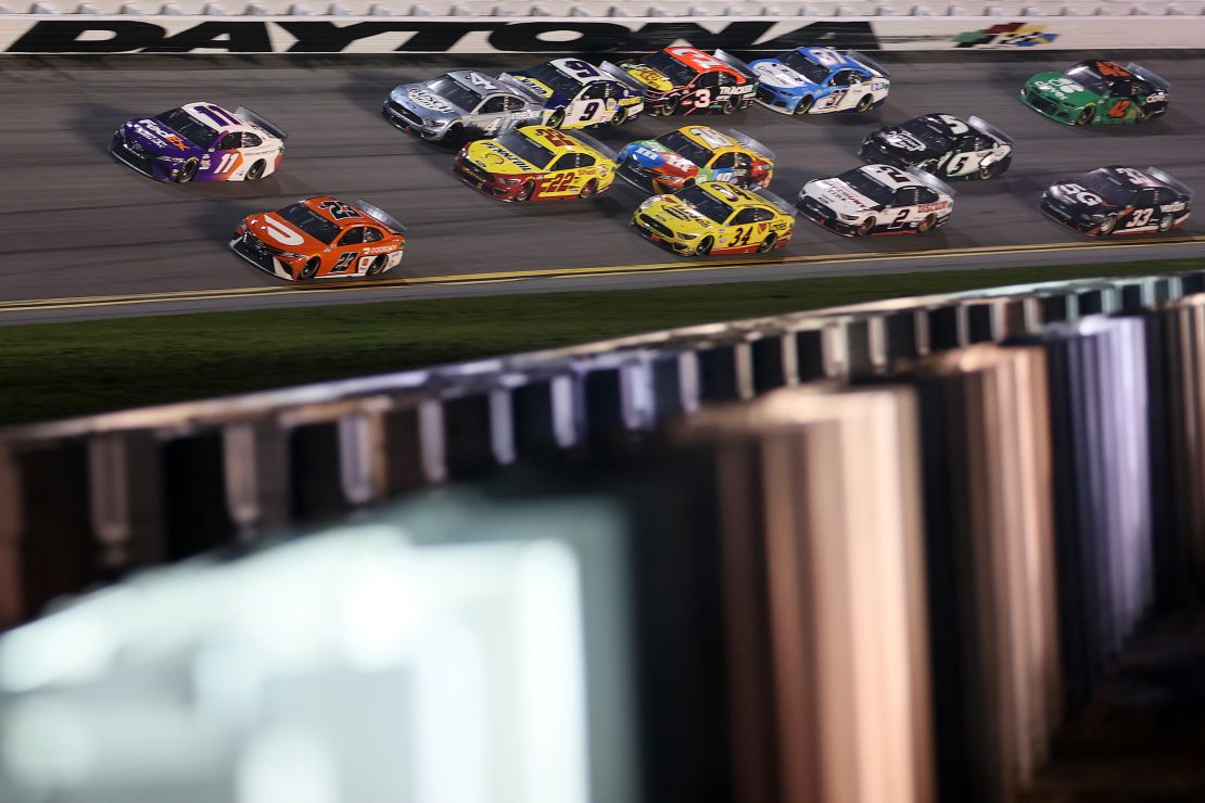 Bubba Wallace, driver of the #23 DoorDash Toyota, and Denny Hamlin, driver of the #11 FedEx Toyota, lead the field during the Daytona 500 in 2021.