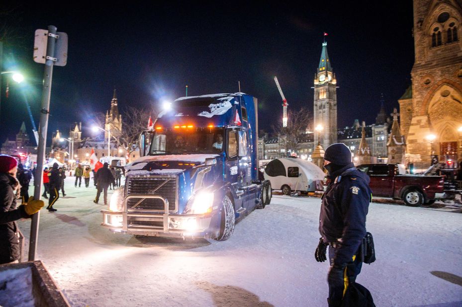 A police officer watches as a truck leaves Parliament Hill in Ottawa on Friday, February 18.