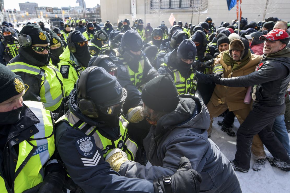 Law enforcement officers confront protesters during a demonstration in Ottawa on Friday.