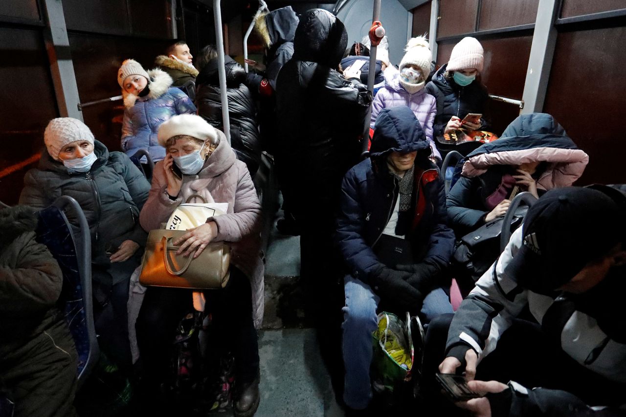 People sit on a bus in Donetsk on February 18 after they were ordered to evacuate to Russia by pro-Russian separatists.