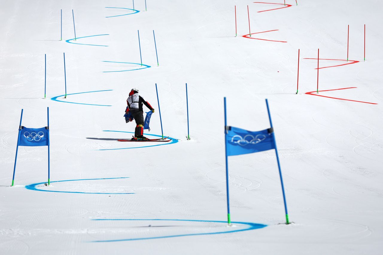 A course worker removes gate flags after the alpine skiing mixed team event was <a href="https://www.cnn.com/world/live-news/beijing-winter-olympics-02-19-22-spt/h_898007b8fba0b1cf63ca478972584e50" target="_blank">postponed due to poor weather conditions</a> on February 19.