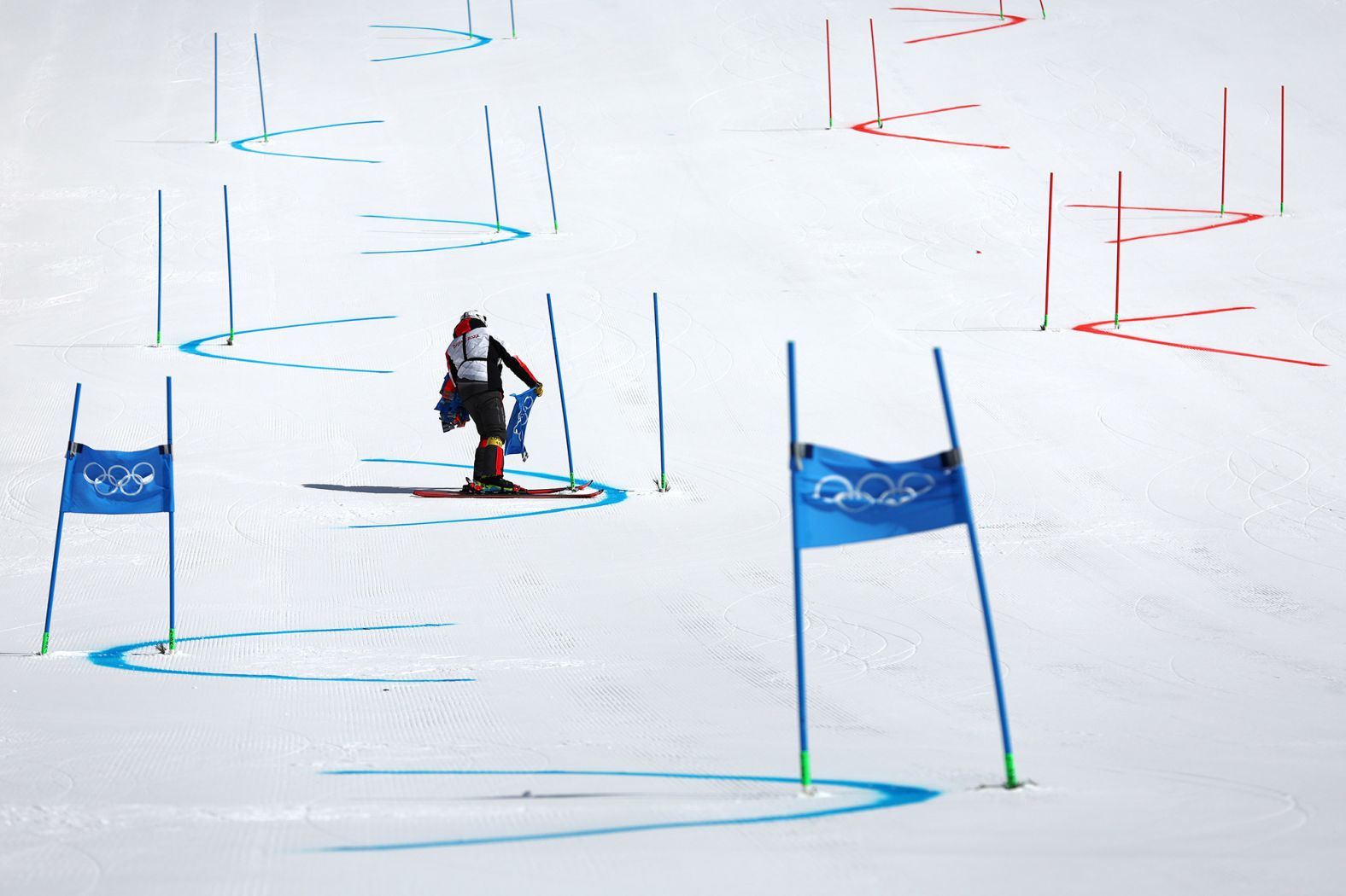 A course worker removes gate flags after the alpine skiing mixed team event was <a href="index.php?page=&url=https%3A%2F%2Fwww.cnn.com%2Fworld%2Flive-news%2Fbeijing-winter-olympics-02-19-22-spt%2Fh_898007b8fba0b1cf63ca478972584e50" target="_blank">postponed due to poor weather conditions</a> on February 19.