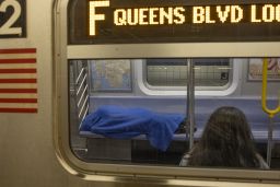 A homeless man sleeps on an F train subway in Brooklyn, New York. 