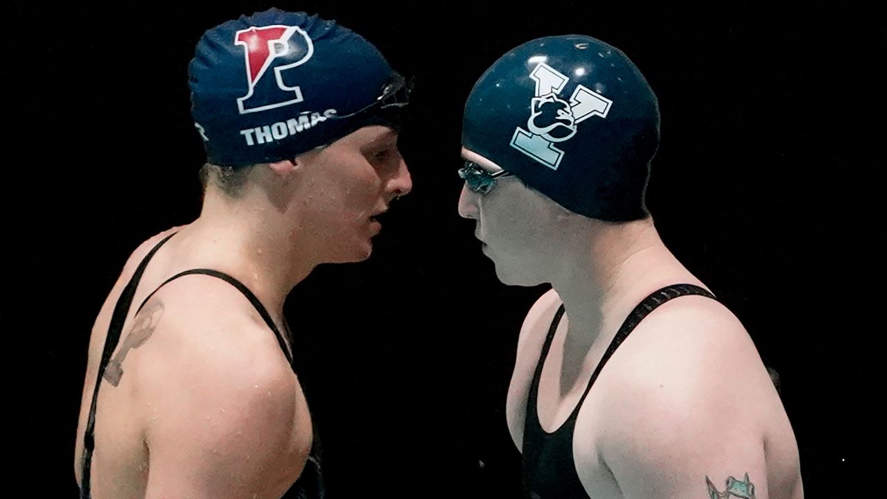 Lia Thomas, left, and Yale's Iszac Henig, right, prepare to swim in a qualifying heat of the 100-yard freestyle on Saturday.