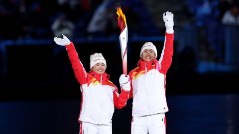 Torch bearers Dinigeer Yilamujiang and Jiawen Zhao of Team China hold the Olympic flame during the opening ceremony on February 4.