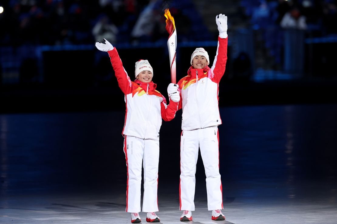 Torch bearers Dinigeer Yilamujiang and Jiawen Zhao of Team China hold the Olympic flame during the opening ceremony on February 4.