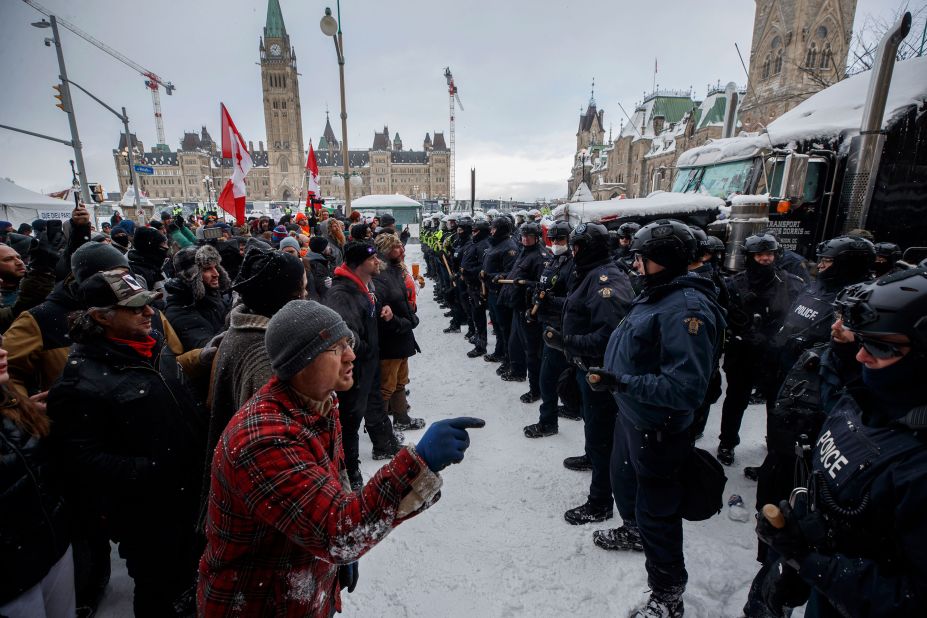 Protesters and police face each other as police move in <a href="https://www.cnn.com/2022/02/19/americas/canada-trucker-protest-covid-saturday/index.html" target="_blank">to clear downtown Ottawa</a> of protesters on Saturday, February 19.