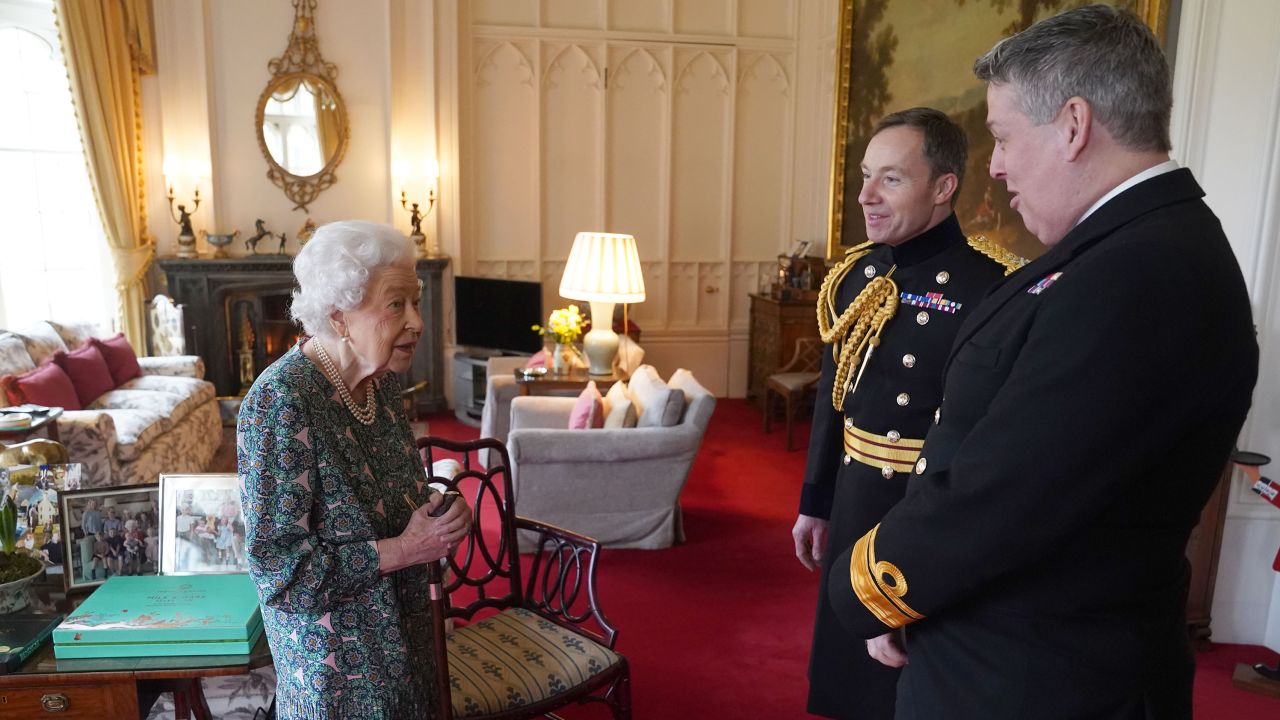 Queen Elizabeth II speaks with Rear Admiral James Macleod and Major General Eldon Millar (right) in the Oak Room at Windsor Castle on February 16. 