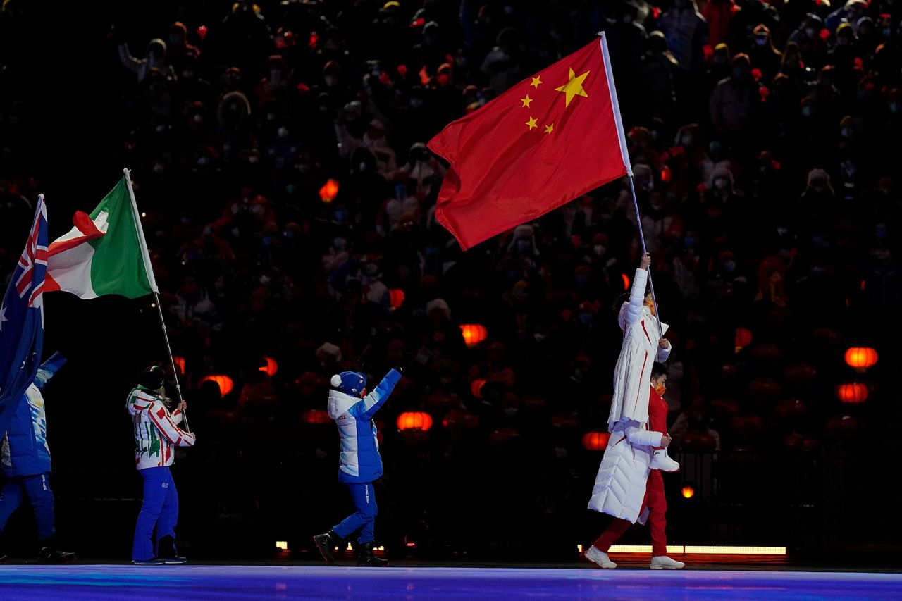 China's Gao Tingyu and Xu Mengtao lead athletes into the stadium during the closing ceremony. Both won gold medals during these Olympics. Gao won in speedskating and Xu won in freestyle skiing.
