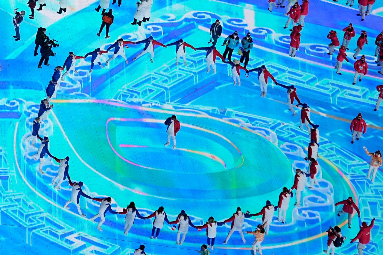 Athletes dance in a circle as they enter the stadium.