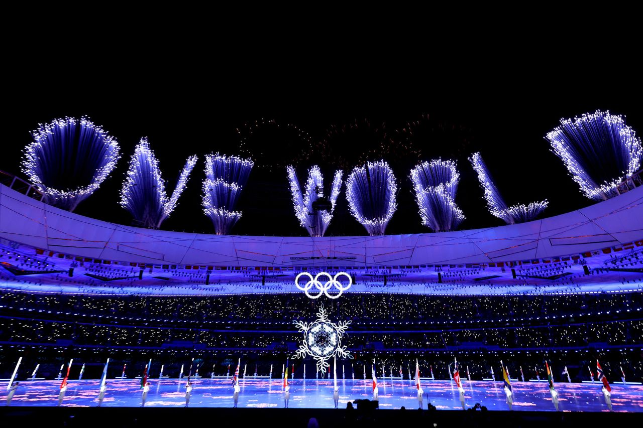A fireworks display spells out "one world."