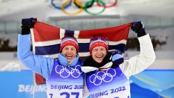 TOPSHOT - Gold medallist Norway's Johannes Thingnes Boe (R) and bronze medallist Norway's Tarjei Boe pose with their national flag after the venue ceremony after the Biathlon Men's 10km Sprint event on February 12, 2022 at the Zhangjiakou National Biathlon Centre during the Beijing 2022 Winter Olympic Games. (Photo by Tobias SCHWARZ / AFP) (Photo by TOBIAS SCHWARZ/AFP via Getty Images)
