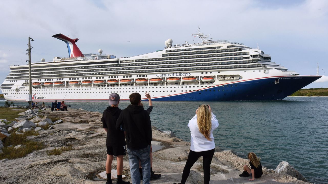 People watch as the Carnival Liberty cruise ship departs from Port Canaveral.