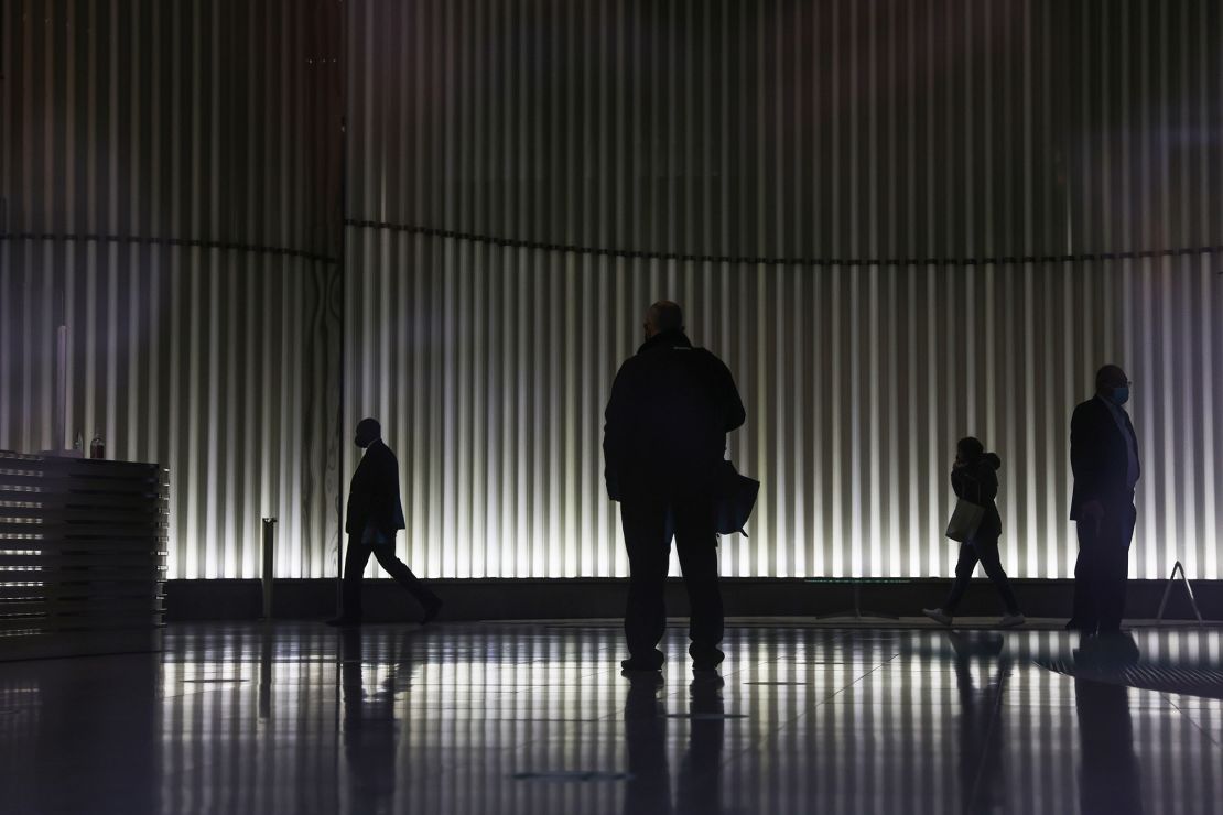 People walk through the lobby of an office building in London in June 2021.