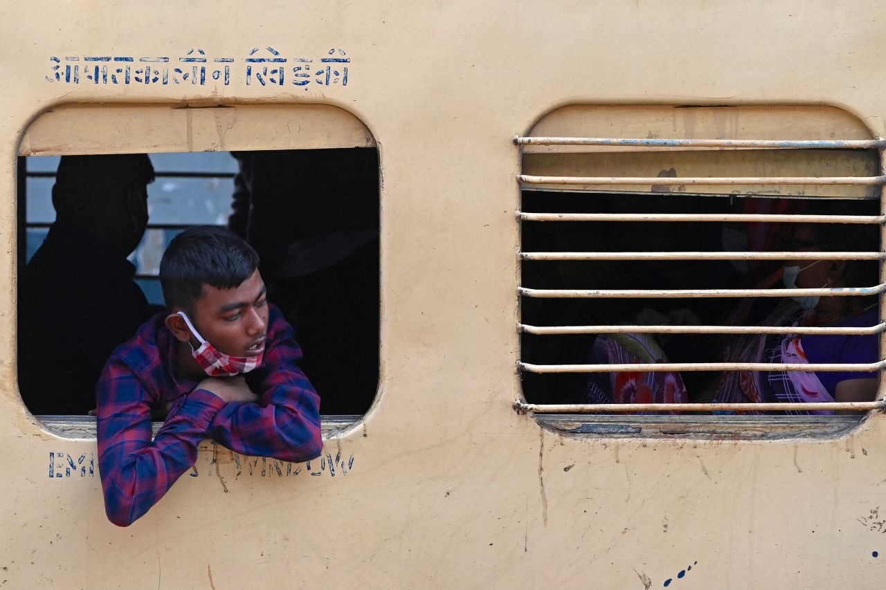 A passenger looks out from the window of a long-distance train at a railway station in Mumbai on January 17, 2022.