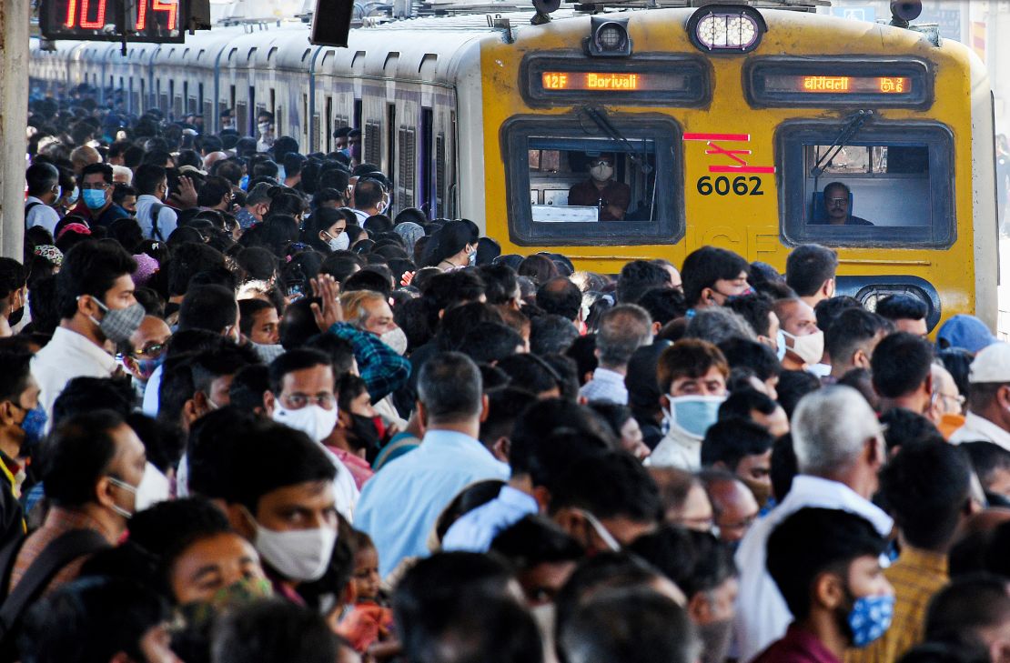 Commuters wait on the platform during rush hour as a local train arrives in Mumbai, on February 1, 2022. 