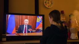 A resident watches a live broadcast of Vladimir Putin, Russia's President, as he delivers an address, on a television in Moscow, Russia, on Monday, Feb. 22, 2022. 