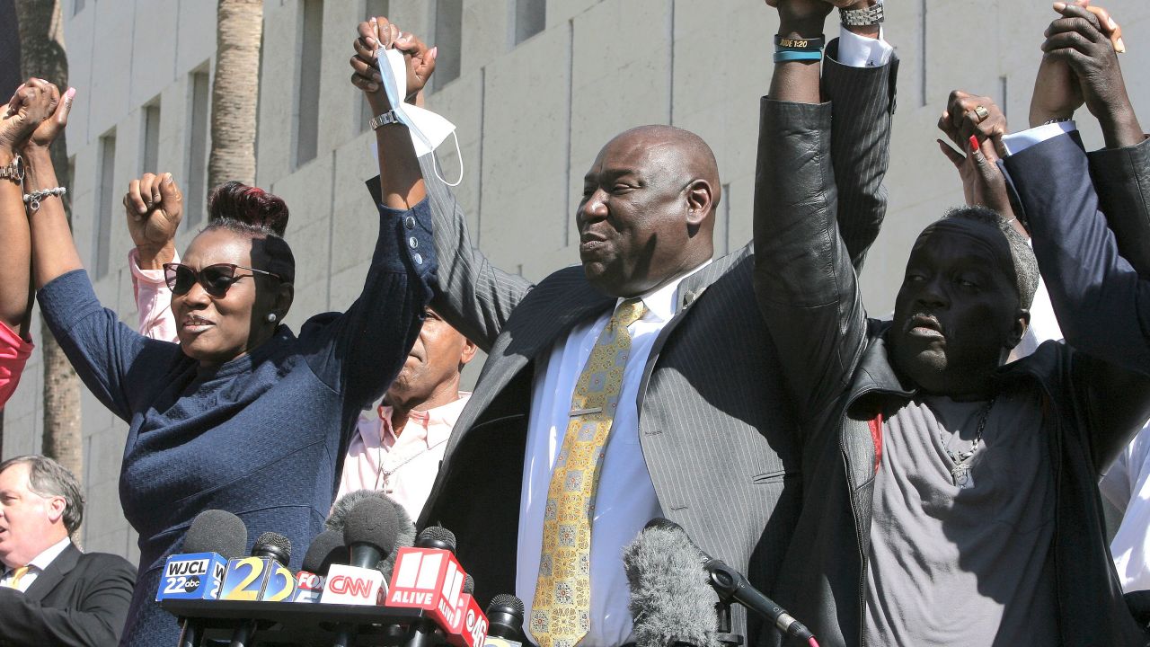 Arbery family attorney Ben Crump (center) clasps hands with Arbery's mother, Wanda Cooper-Jones, and Arbery's father, Marcus Arbery Sr., outside the court on Tuesday.