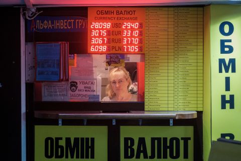 A sign displays conversion rates at a currency exchange kiosk in Kyiv on February 22. Global markets tumbled the day after Putin ordered troops into parts of eastern Ukraine.
