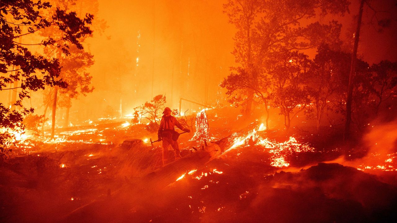 TOPSHOT - A firefighter works the scene as flames push towards homes during the Creek fire in the Cascadel Woods area of unincorporated Madera County, California on September 7, 2020. - A firework at a gender reveal party triggered a wildfire in southern California that has destroyed 7,000 acres (2,800 hectares) and forced many residents to flee their homes, the fire department said Sunday. More than 500 firefighters and four helicopters were battling the El Dorado blaze east of San Bernardino, which started Saturday morning, California Department of Forestry and Fire Protection (Cal Fire) said. (Photo by JOSH EDELSON / AFP) (Photo by JOSH EDELSON/AFP via Getty Images)