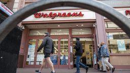 Pedestrians wearing walk past a Walgreens store in San Francisco, California, U.S., on Tuesday, April 13, 2021. 
